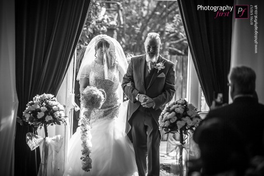Bride and father entering ceremony room from the courtyard