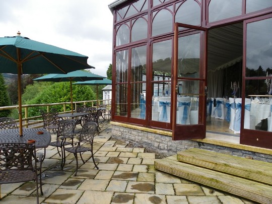 Craig y Nos Castle Wedding Venue in Swansea showing the Conservatory terraces and wrought iron tables 