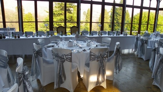Craig y Nos Castle Wedding Venue Wedding Breakfast tables set up with silver sashes on whilte chair covers