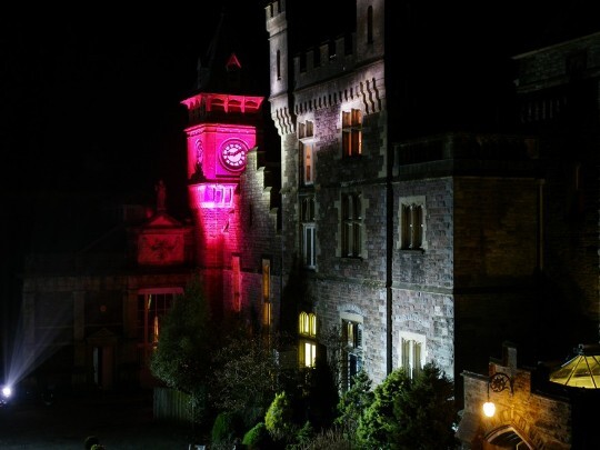 Craig y Nos Castle Wedding Venue Swansea Floodlit at Night in grey and purple alternating colours