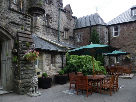 Craig y Nos Castle Wedding Venue Front Courtyard teak garden seats and tables with green canopies