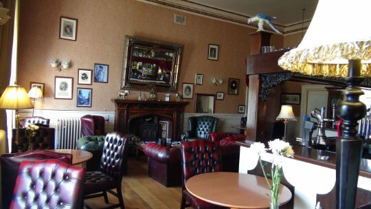 Craig y Nos Castle Patti Bar leather chesterfield sofas, Edwardian fireplace, wall with pictures of Adelina Patti