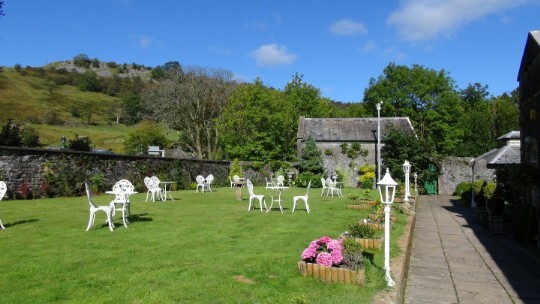 The lawned theatre gardens white tables and chairs. Craig y Nos Castle in South Wales