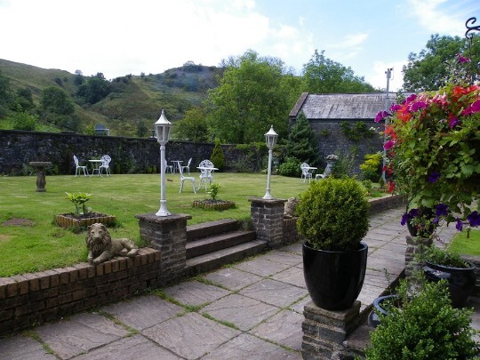 Craig y Nos Castle Wedding Venue raised lawn in the Theatre Gardens with slabbed pathways alongside theatre