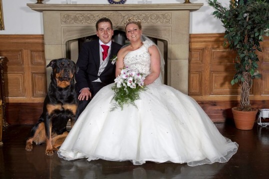 Bride and Groom with their dog Roxy in front of the fire place in music room at Craig y Nos Castle