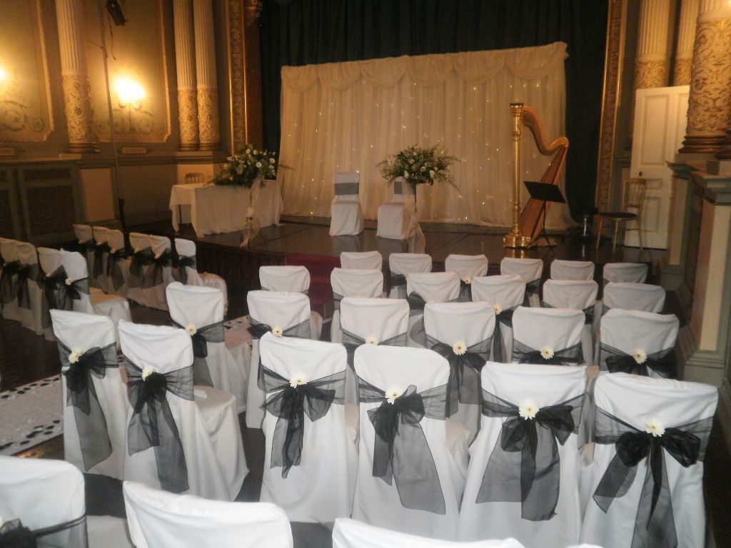 Craig y Nos Castle Wedding Ceremony Room with white chair covers and harp on stage